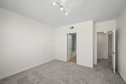 an empty room with closet and a hallway