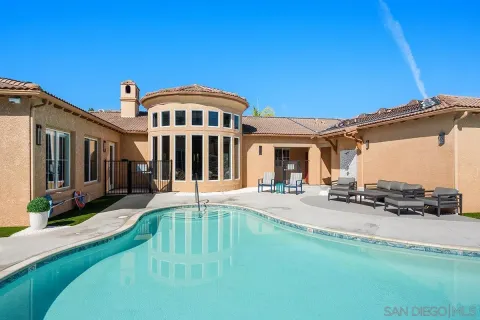 a view of a patio with table and chairs under an umbrella
