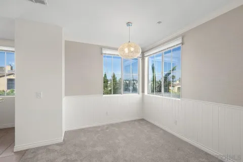an empty room with a windows and chandelier