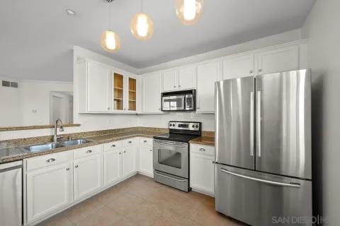 a kitchen with stainless steel appliances granite countertop a refrigerator sink and stove