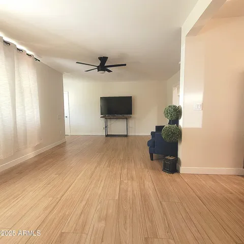 a view of a livingroom with a hardwood floor and a ceiling fan