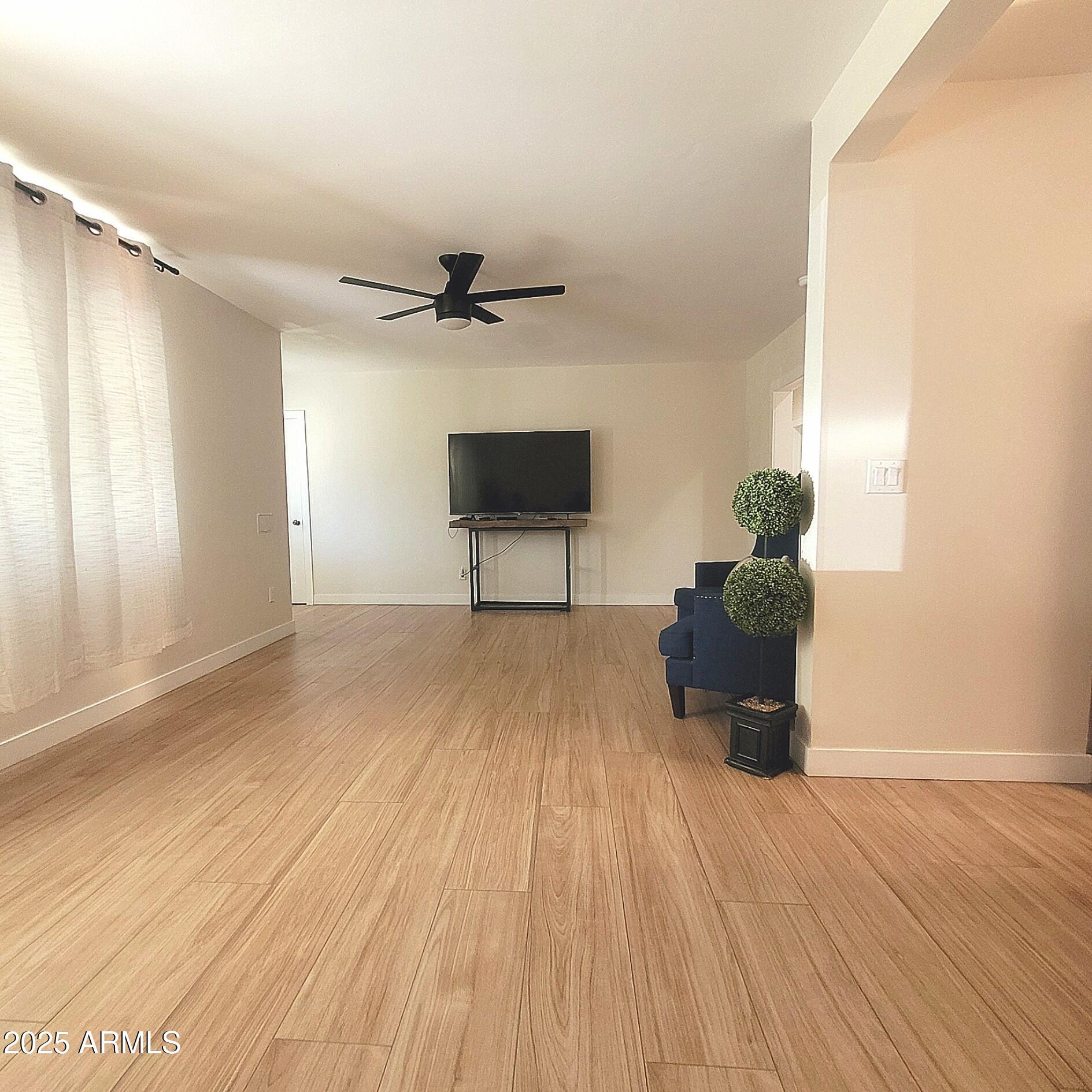 4028 East Edgemont Avenue Phoenix, AZ 85018 - Photo 12 of 27 a view of a livingroom with a hardwood floor and a ceiling fan