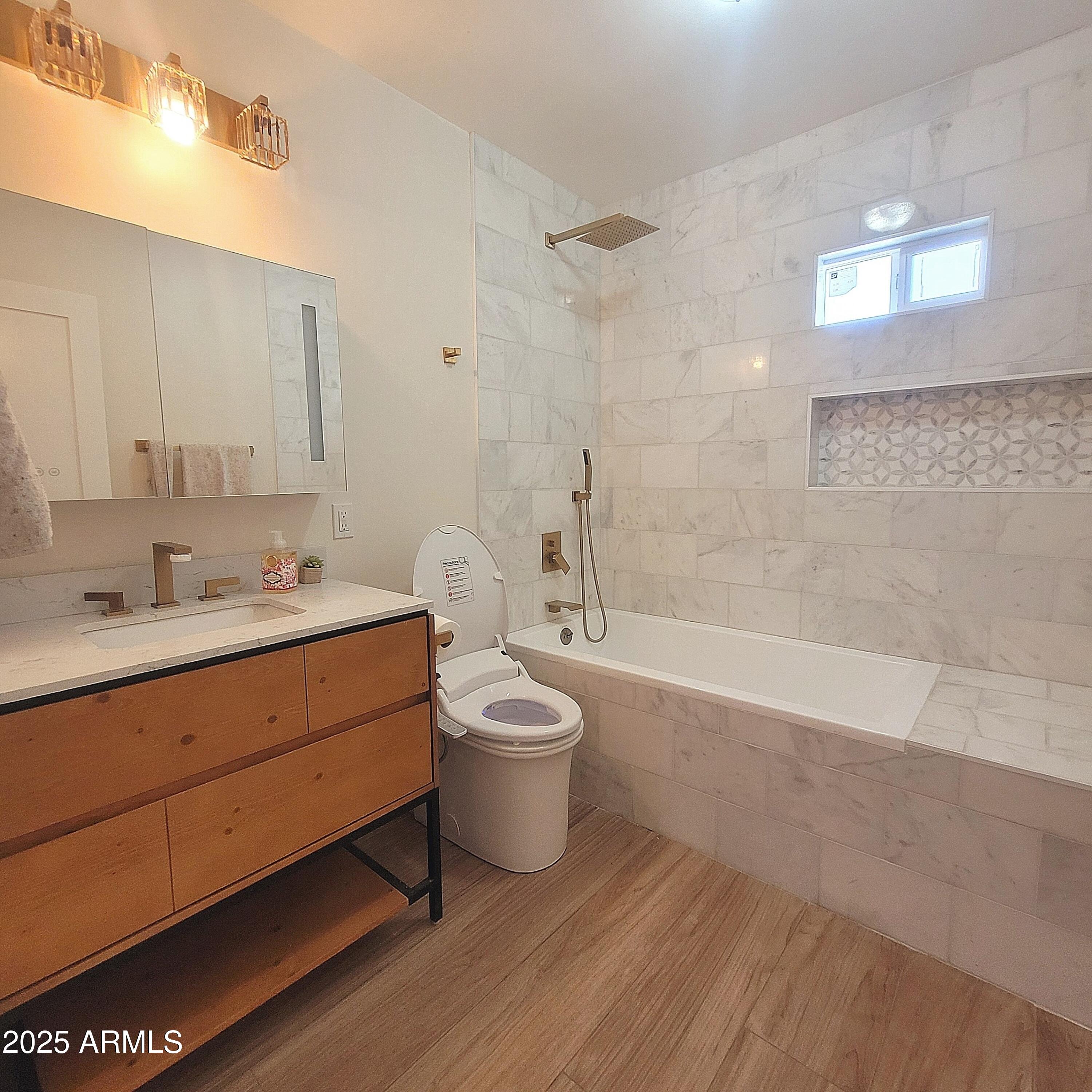 4028 East Edgemont Avenue Phoenix, AZ 85018 - Photo 18 of 27 a bathroom with a granite countertop toilet a sink and bathtub