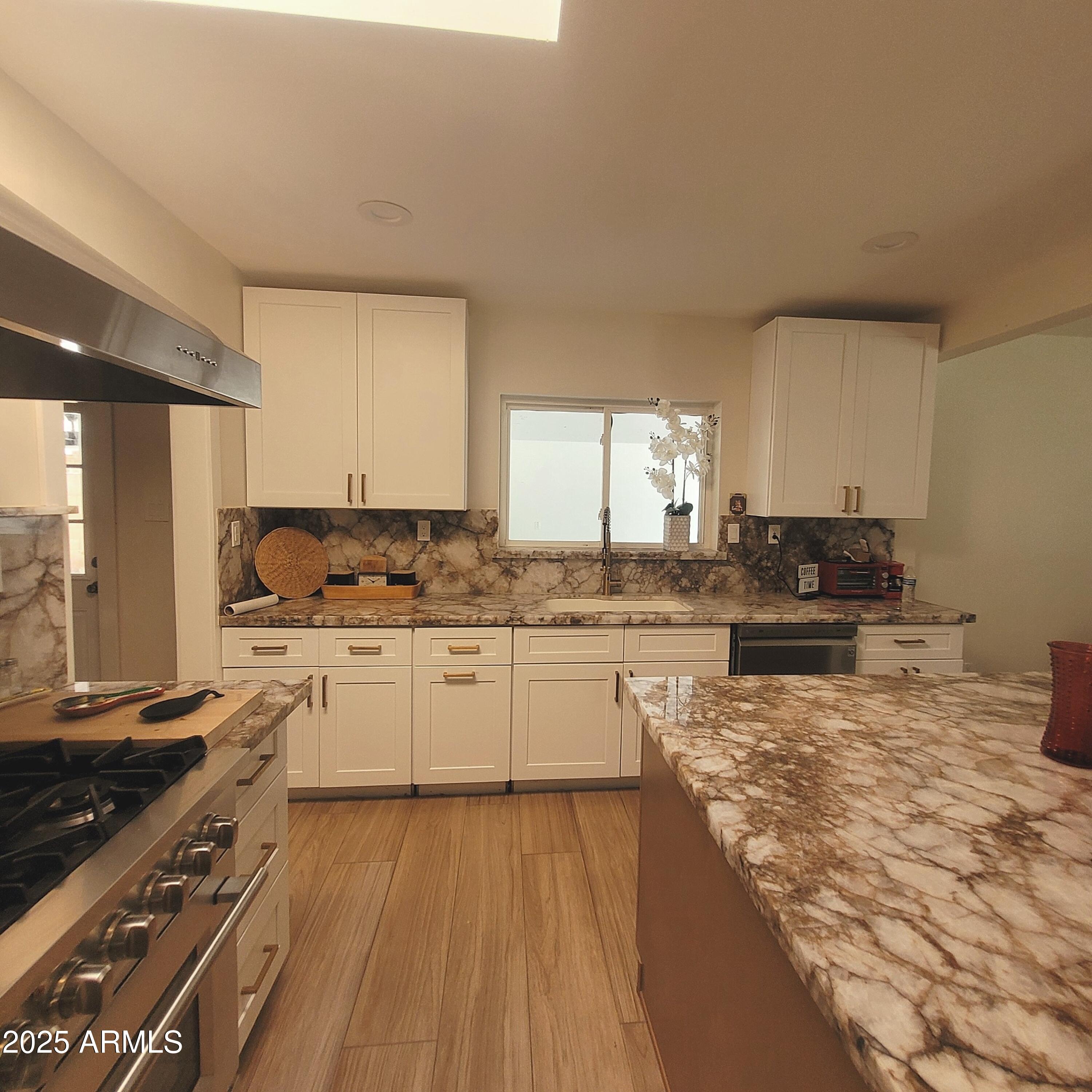 4028 East Edgemont Avenue Phoenix, AZ 85018 - Photo 6 of 27 a kitchen with granite countertop a stove top oven sink and cabinets