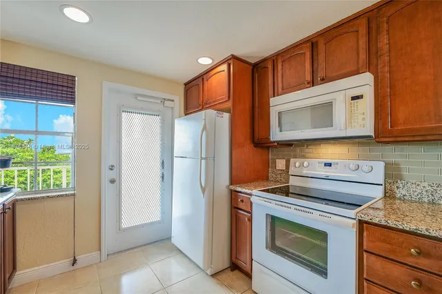 a kitchen with stainless steel appliances granite countertop a refrigerator stove and cabinets