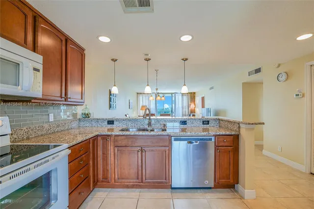 a kitchen with a sink a stove a refrigerator and cabinets