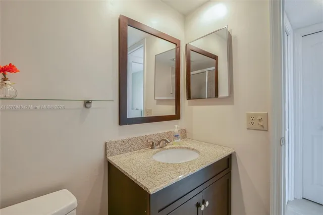 a bathroom with a granite countertop sink and a mirror