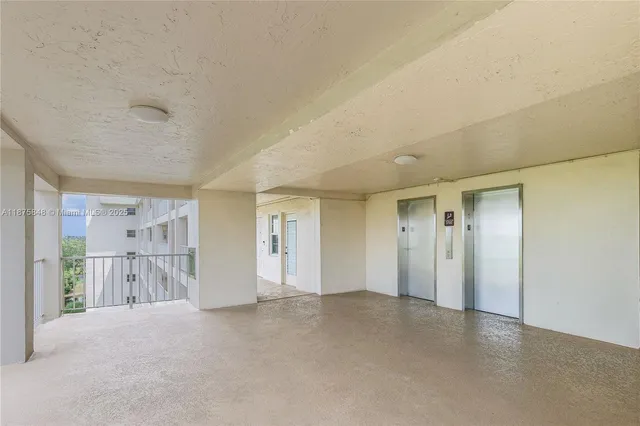 a view of an empty room with windows and a ceiling fan