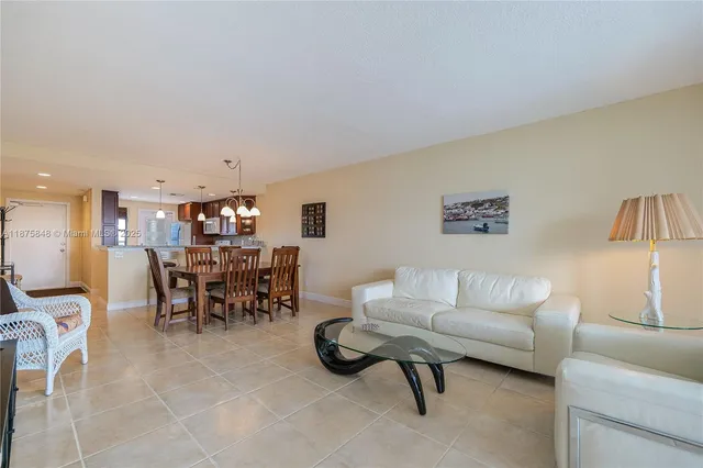 a living room with furniture and a dining table with projector