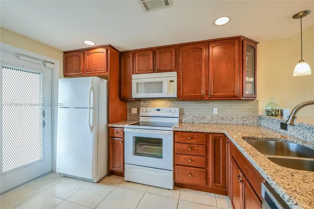 a kitchen with stainless steel appliances granite countertop a refrigerator stove and sink