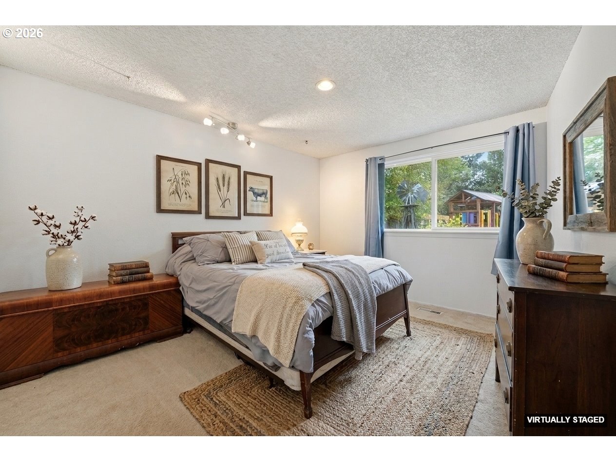 892 Northeast 28th Street Gresham, OR 97030 - Photo 14 of 24 a spacious bedroom with a bed and wooden floor