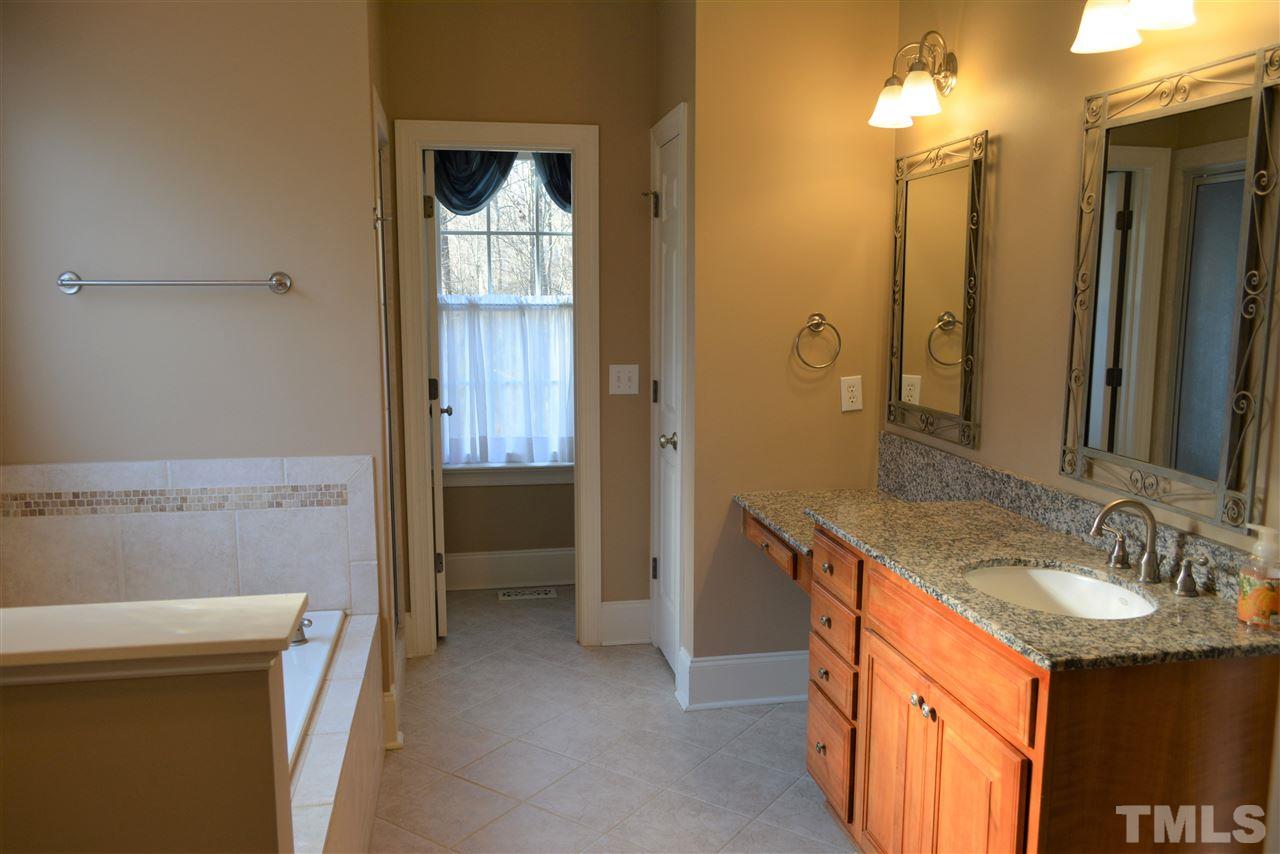 1316 Wynncrest Court Raleigh, NC 27603 - Photo 17 of 30 a bathroom with a sink a vanity and a mirror