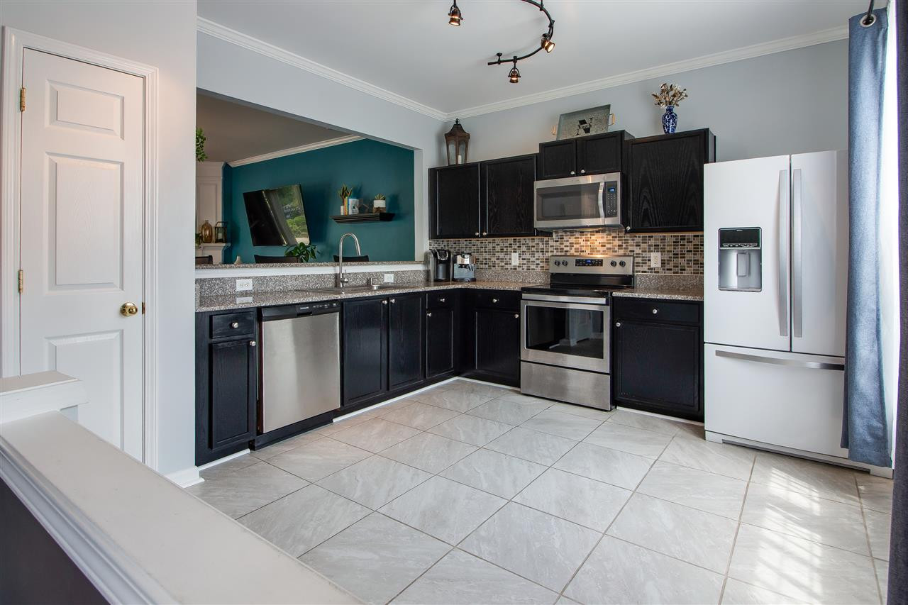 5022 Echo Ridge Road Raleigh, NC 27612 - Photo 3 of 22 a kitchen with stainless steel appliances granite countertop a stove top oven a refrigerator and a sink with granite countertops