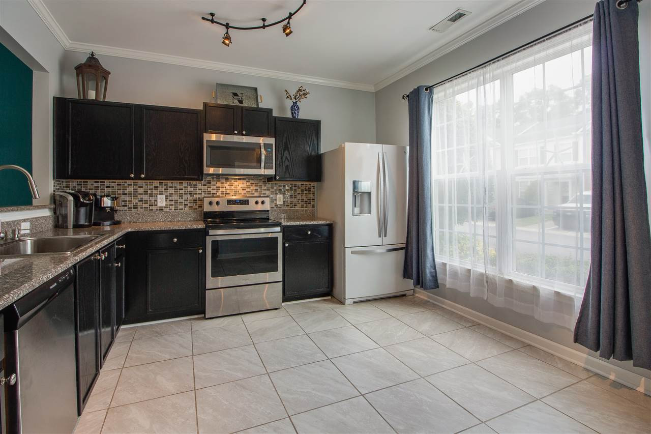 5022 Echo Ridge Road Raleigh, NC 27612 - Photo 4 of 22 a kitchen with stainless steel appliances granite countertop a stove refrigerator and microwave