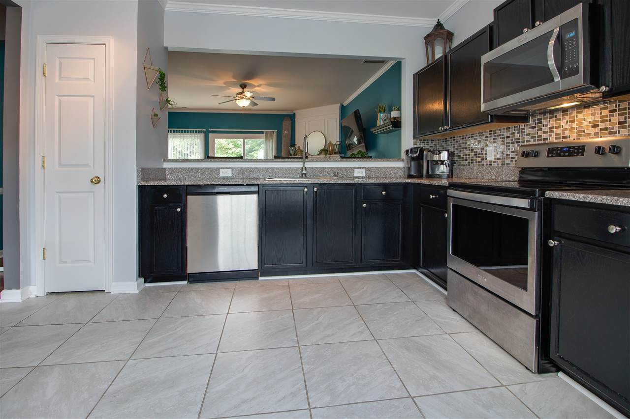 5022 Echo Ridge Road Raleigh, NC 27612 - Photo 5 of 22 a kitchen with stainless steel appliances granite countertop a stove and a microwave
