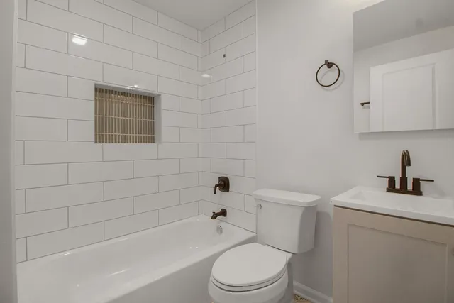 a bathroom with a toilet sink a mirror and bathtub