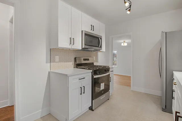 a kitchen with stainless steel appliances granite countertop a stove and a refrigerator