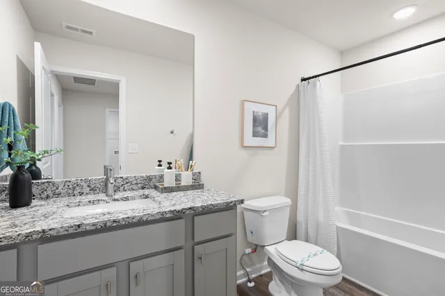 a bathroom with a granite countertop sink toilet and shower