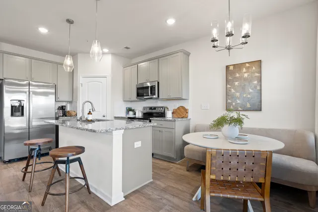 a kitchen with cabinets a counter and chairs