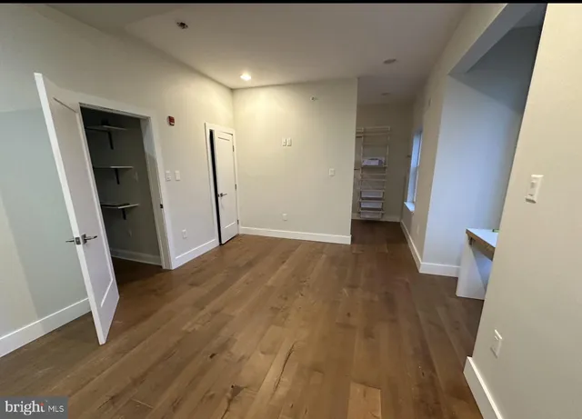 an empty room with wooden floor and entrance