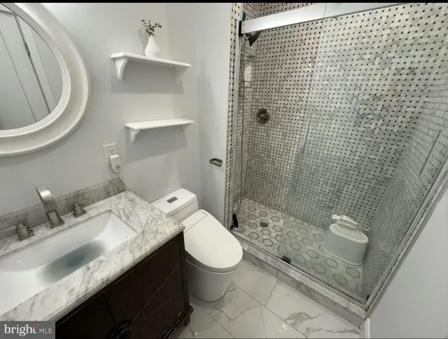 a bathroom with a granite countertop sink a toilet and shower