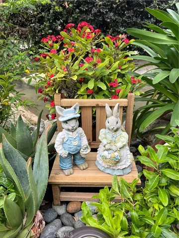 a view of a chair and tables in backyard of house