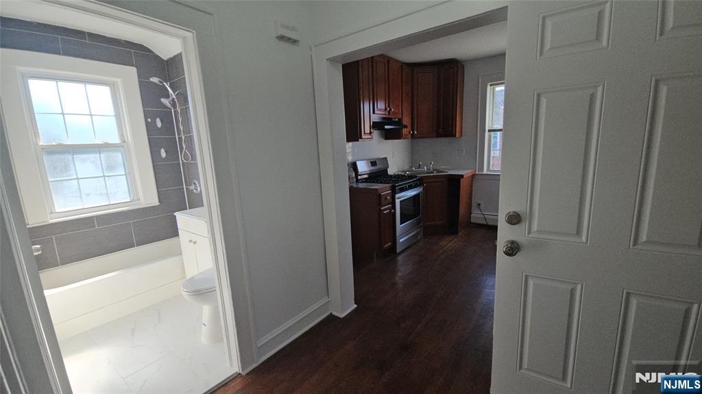 264-266 Pomona Avenue, Unit 3 Newark, NJ 07112 - Photo 18 of 27 a kitchen with kitchen island wooden floors appliances and cabinets