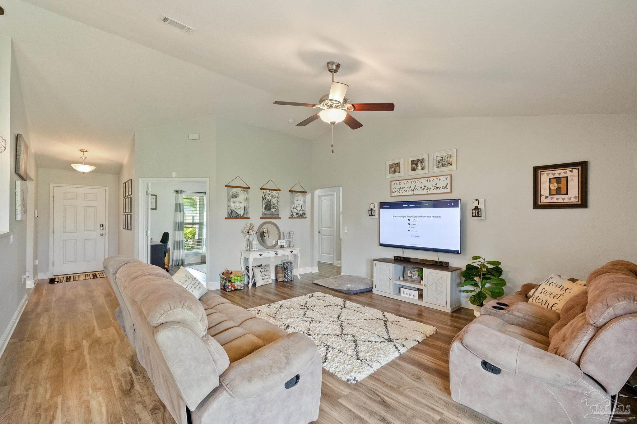 4037 Millwright Way Pace, FL 32571 - Photo 16 of 46 a living room with furniture a fireplace and a chandelier