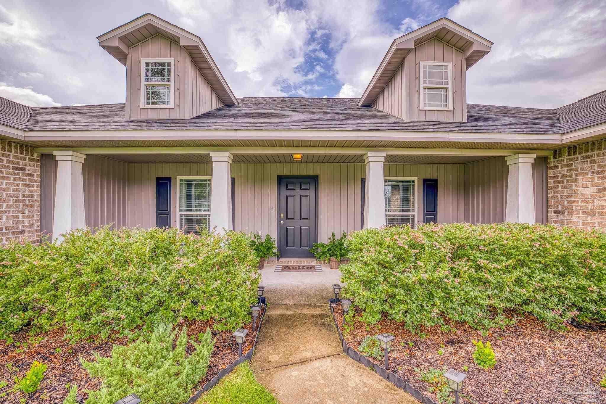4037 Millwright Way Pace, FL 32571 - Photo 2 of 46 front view of a brick house with large windows