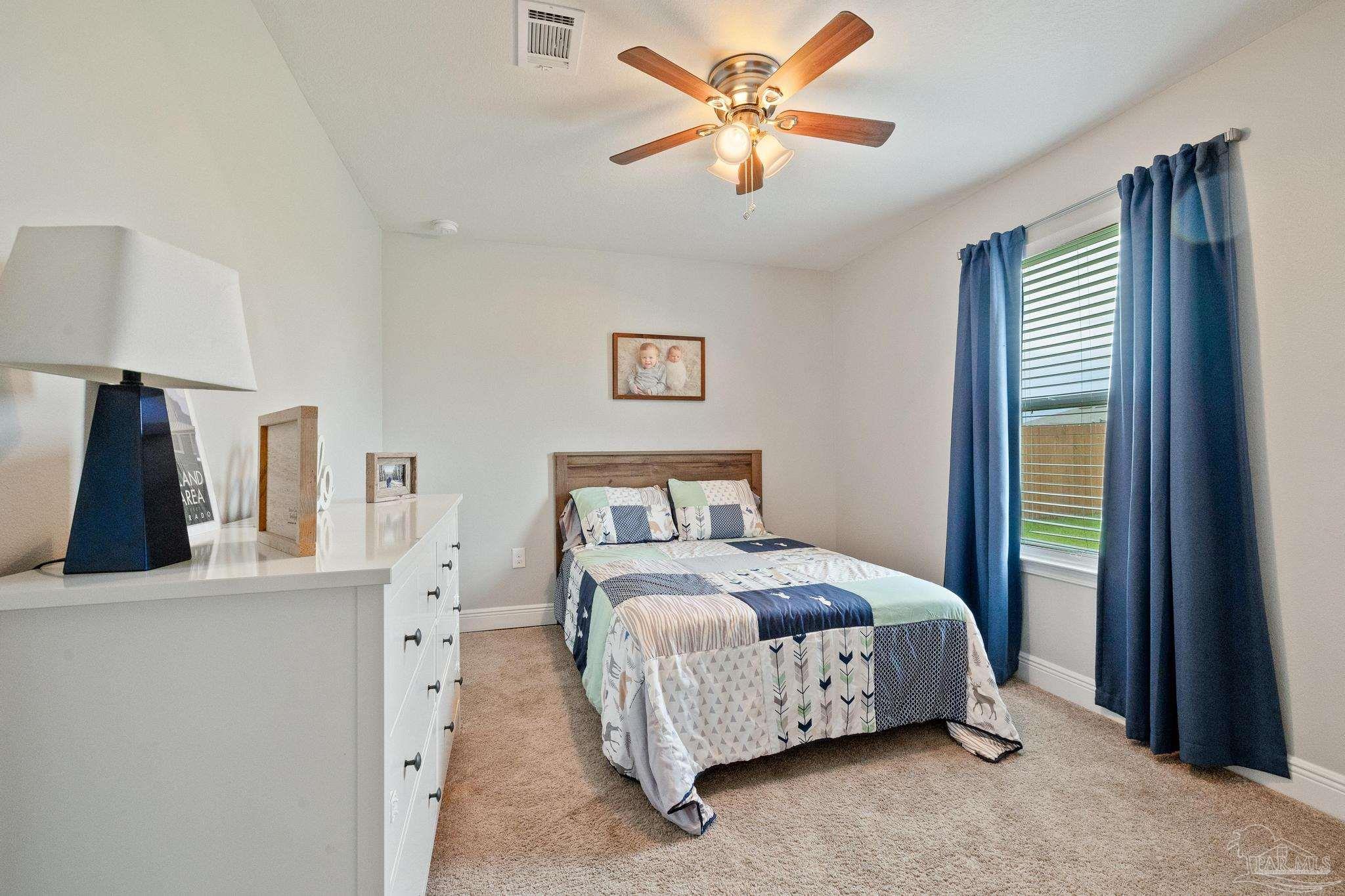 4037 Millwright Way Pace, FL 32571 - Photo 32 of 46 a spacious bedroom with a bed and a chandelier