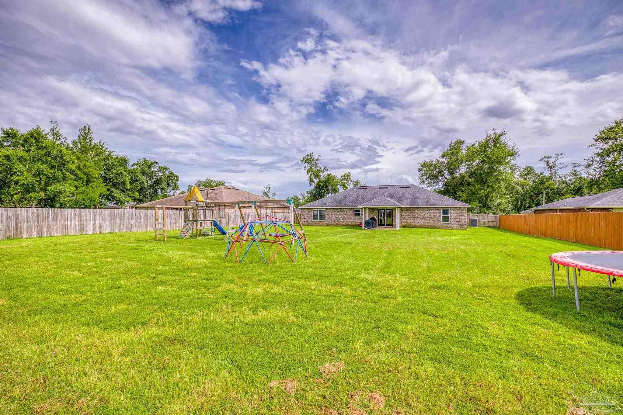4037 Millwright Way Pace, FL 32571 - Photo 44 of 46 a view of a garden with a bench in the garden