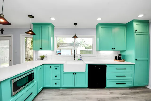 a large kitchen with kitchen island a large counter top space a sink stainless steel appliances and cabinets