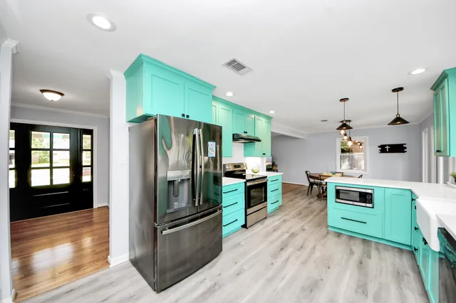 a kitchen with stainless steel appliances a refrigerator and a stove top oven