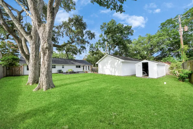 a view of a house with backyard and a tree