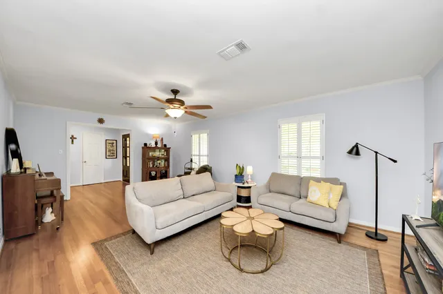 a living room with furniture and a wooden floor