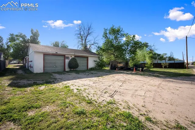 a view of a house with backyard and a garden