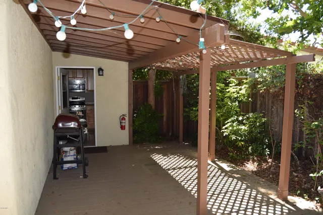 a view of a backyard with plants and wooden fence