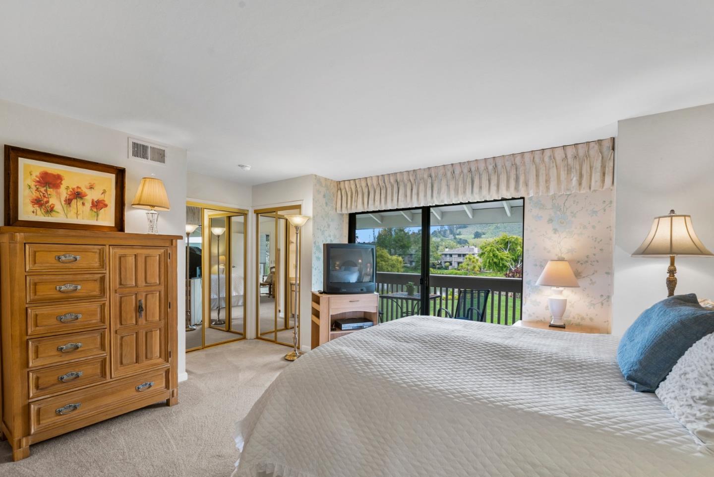 3850 Rio Road, Unit 21 Carmel, CA 93923 - Photo 11 of 31 a bedroom with a balcony a bed a dresser and a large window