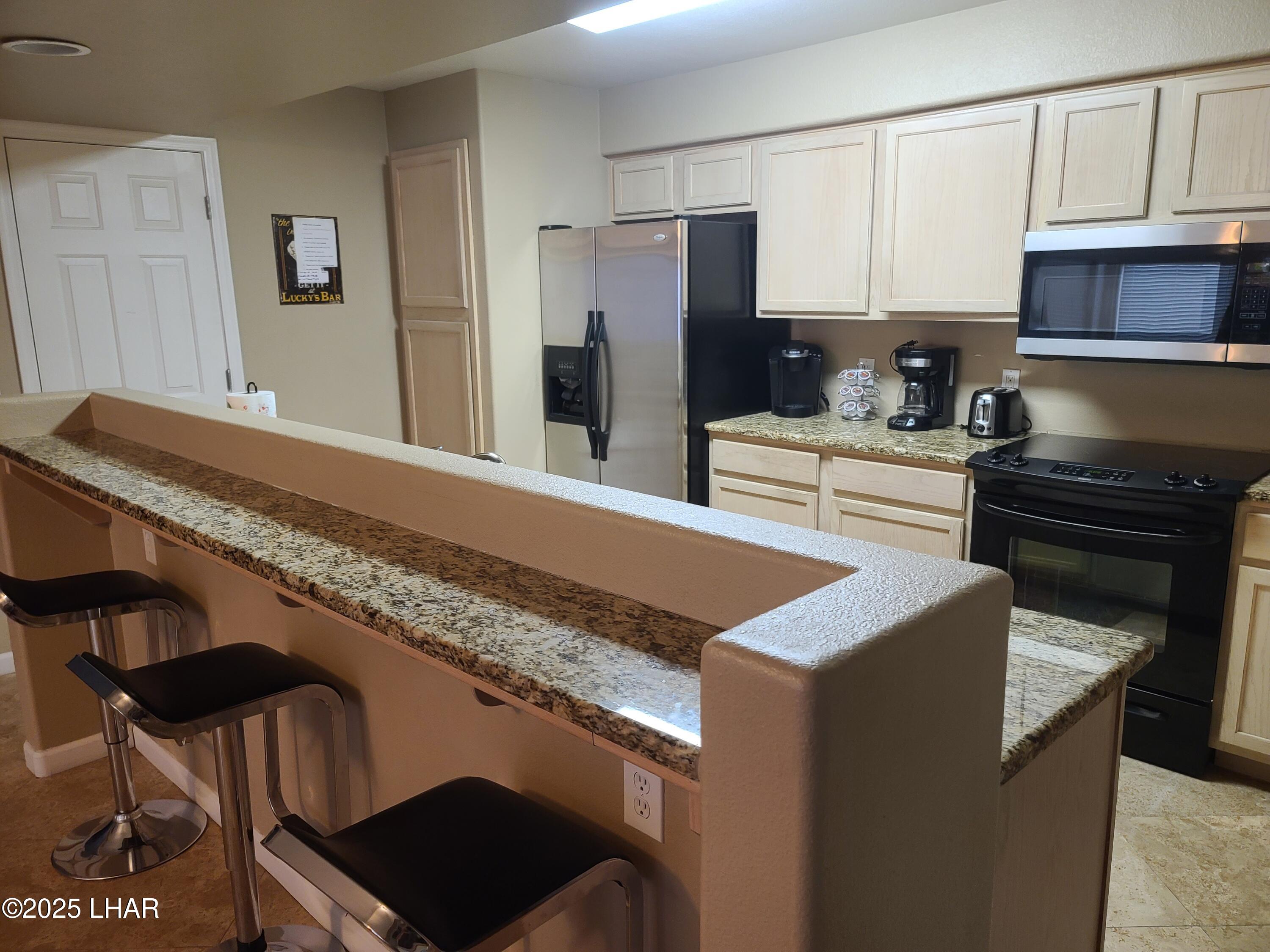 94 London Bridge Road, Unit 108 Lake Havasu City, AZ 86403 - Photo 33 of 38 a kitchen with granite countertop a refrigerator stove and sink