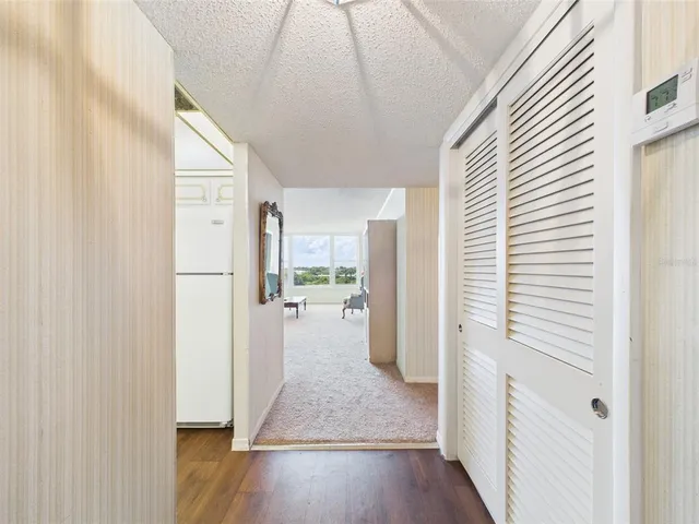 a view of a hallway with wooden floor and a living room