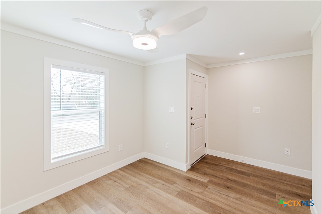 404 Bridge Street Cuero, TX 77954 - Photo 12 of 40 an empty room with wooden floor and windows