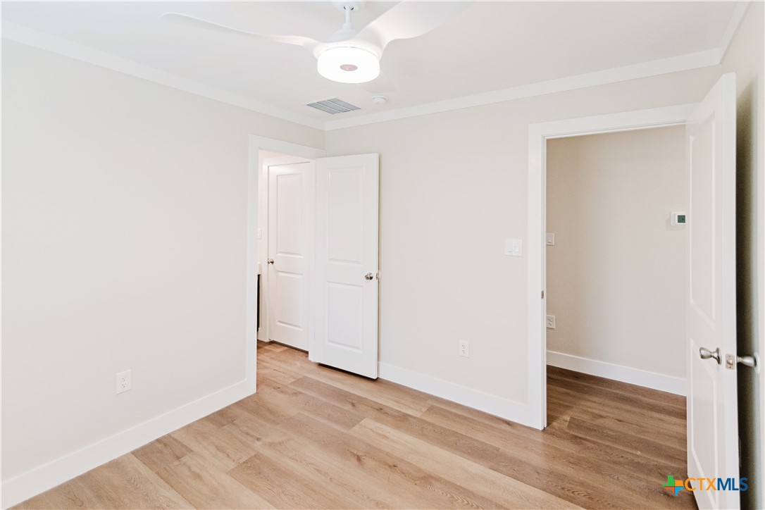 404 Bridge Street Cuero, TX 77954 - Photo 17 of 40 an empty room with wooden floor and windows