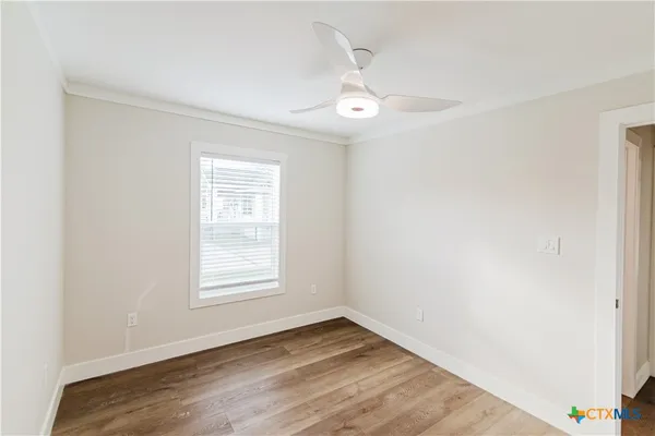 a view of an empty room with wooden floor