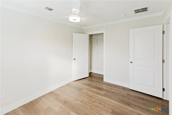 a view of an empty room with wooden floor