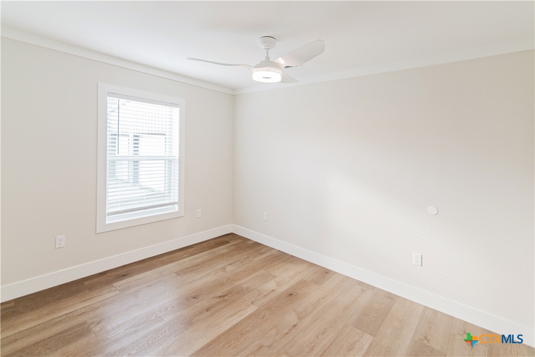 404 Bridge Street Cuero, TX 77954 - Photo 28 of 40 a view of an empty room with wooden floor and a window