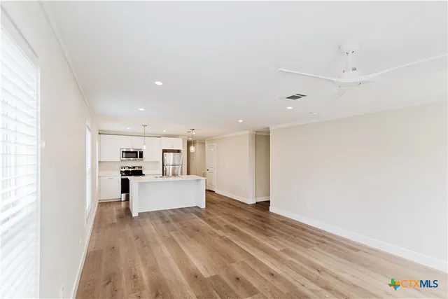 a view of an empty room with wooden floor
