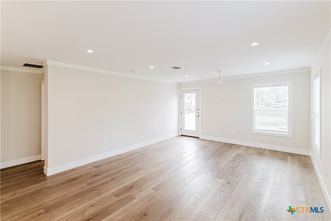 404 Bridge Street Cuero, TX 77954 - Photo 34 of 40 an empty room with wooden floor and windows