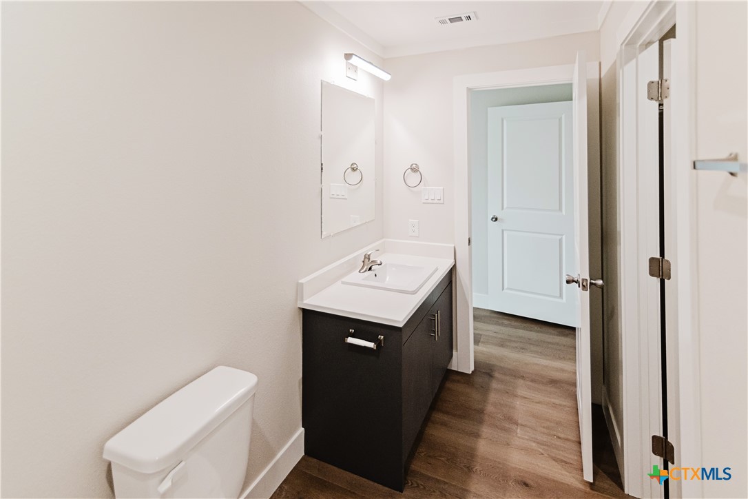 404 Bridge Street Cuero, TX 77954 - Photo 38 of 40 a bathroom with a toilet sink and mirror