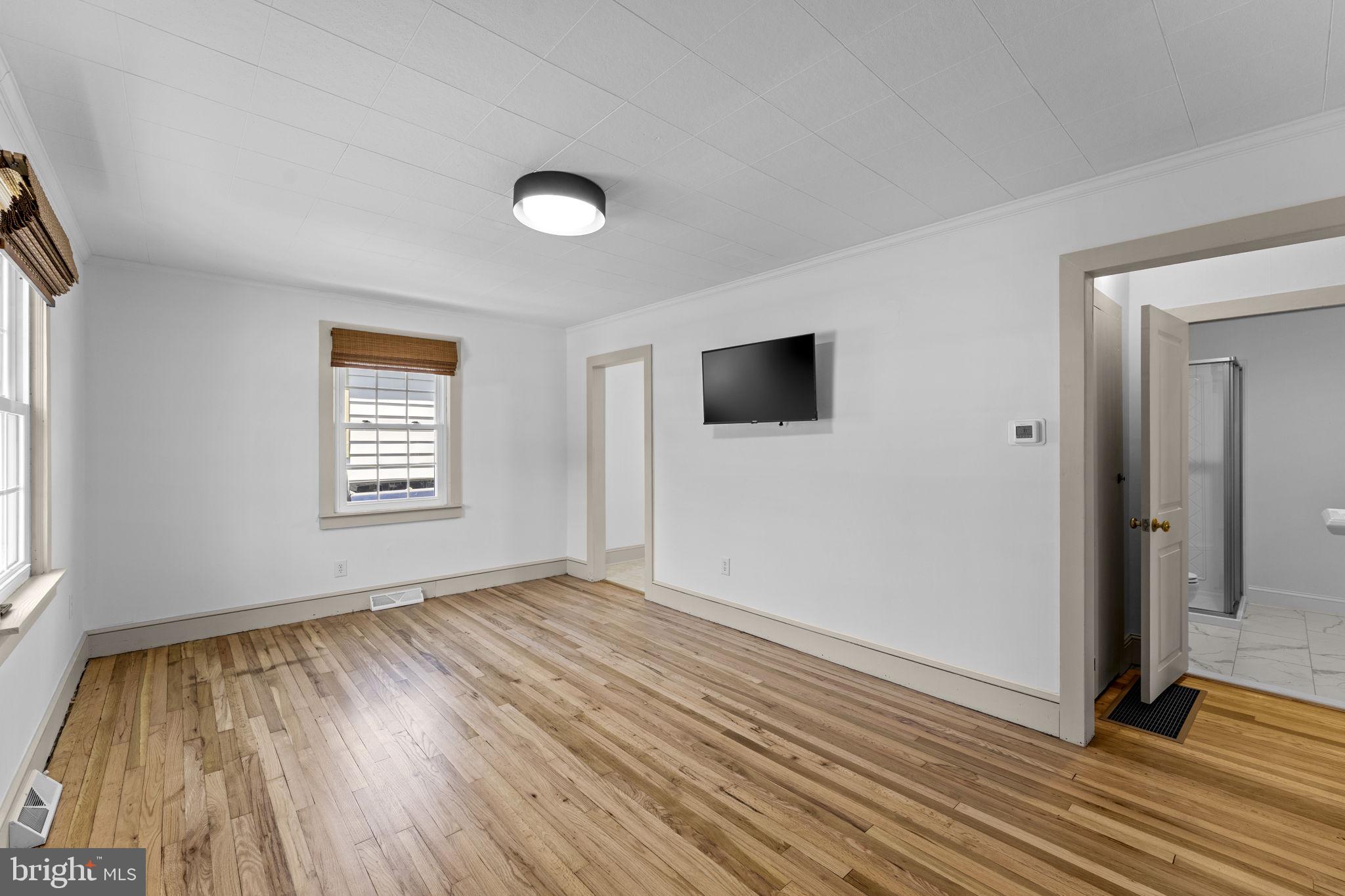 216 Walnut Street Berryville, VA 22611 - Photo 4 of 36 an empty room with wooden floor and windows