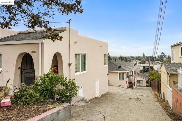 a view of a blue house with iron fence